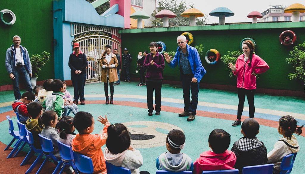 A photo of me and others in a tour group in front of chinese school children teaching them a song in English.