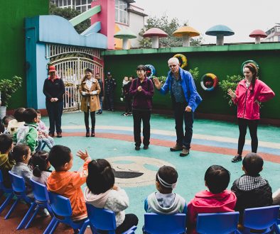 A photo of me and others in a tour group in front of chinese school children teaching them a song in English.